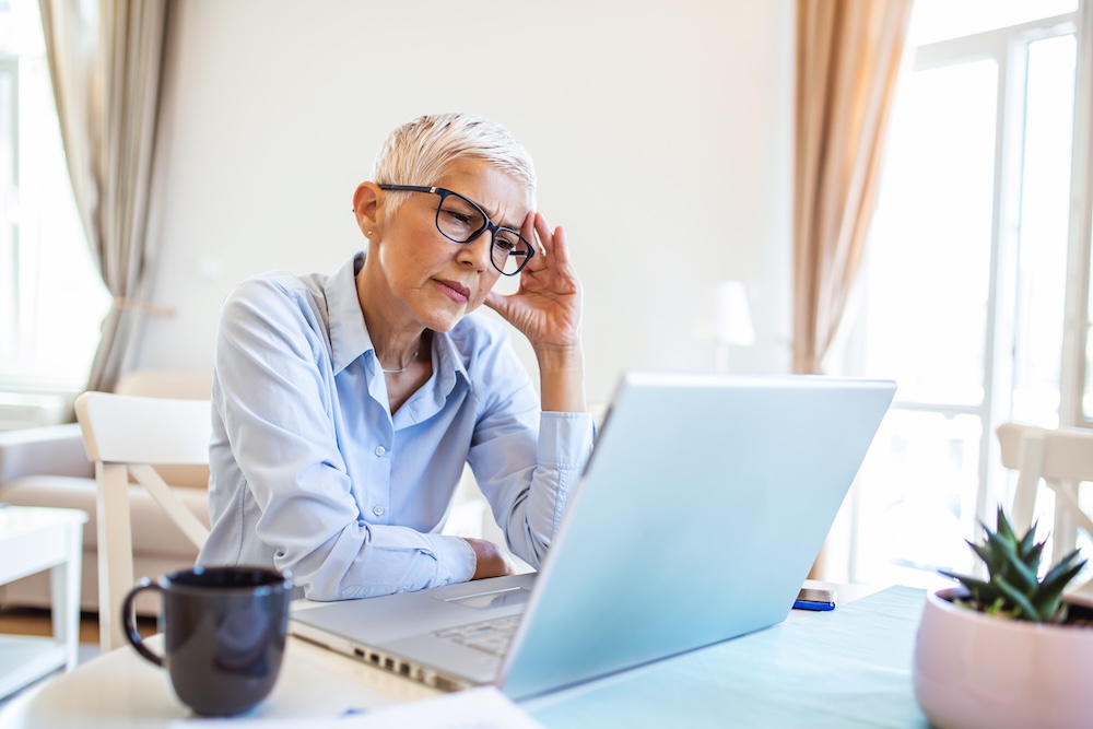 Mature business woman concerned thinking about online problem.Frustrated worried senior middle aged female suffering from memory loss